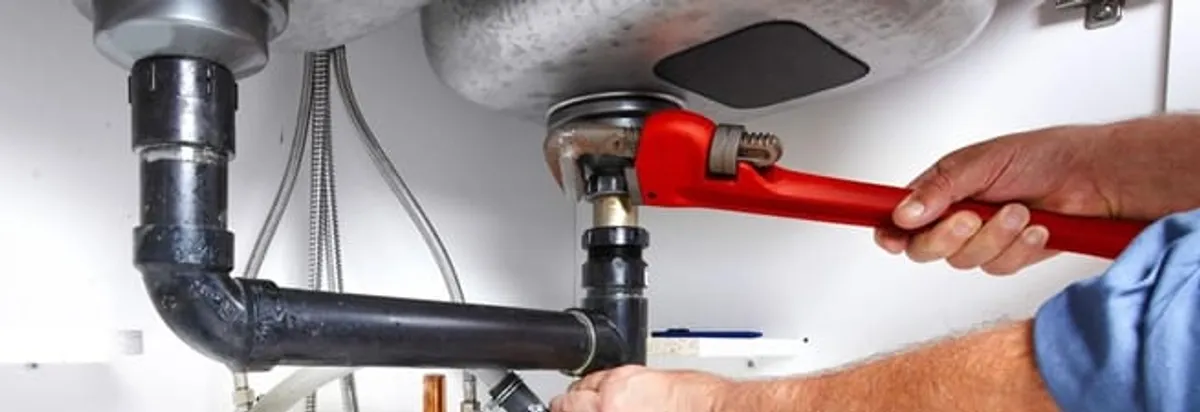 Garbage disposal repair technician tightening the sink drain and disposal connection in St Paul, MN