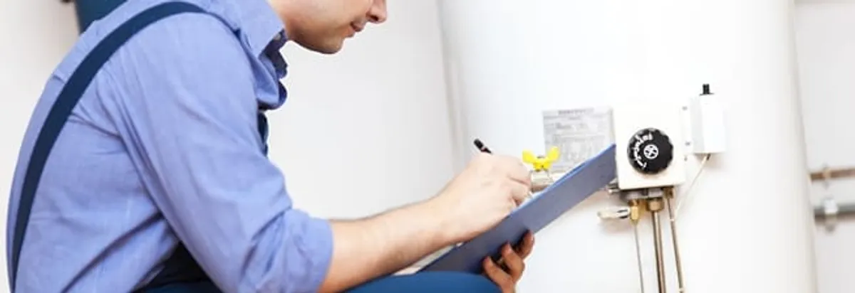 Water heater repair technician inspecting the unit and recording service notes in St Paul, MN